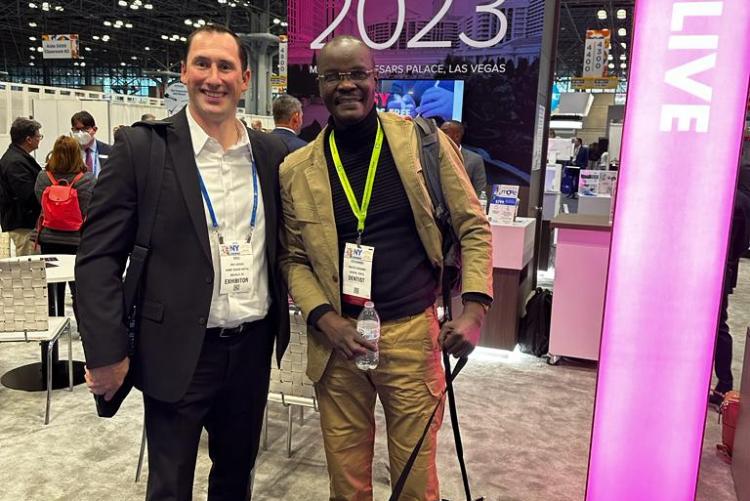 Dr. Odhiambo pose for a photograph with Eric  marketing Director Henry Schein at the Greater New York Dental Meeting
